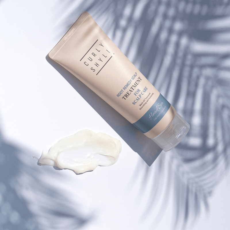 Tube of Curly Shaky scalp treatment with a sample on a textured background
